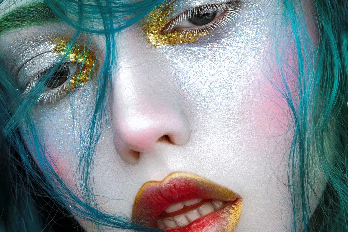 close-up portrait of beautiful woman's face in a dark, fantasy makeup look inspired by mermaid aesthetic