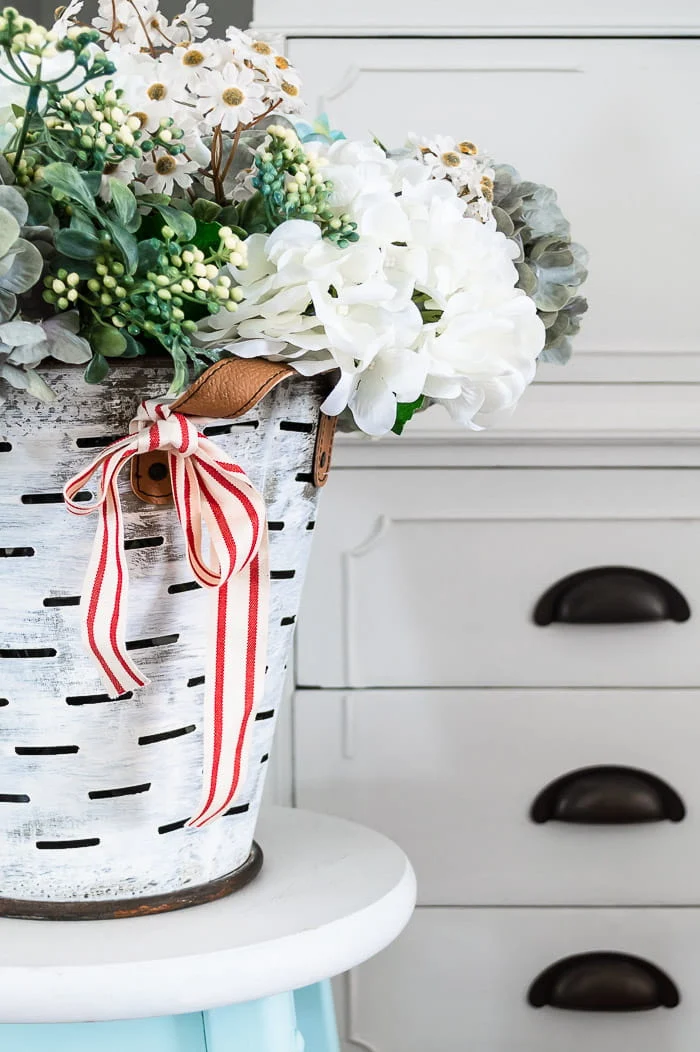 white washed olive bucket, hydrangeas, red striped ribbon