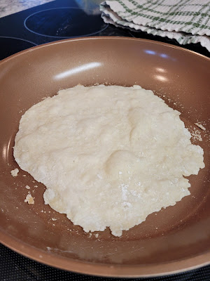 Tortilla in pan starting to bubble.