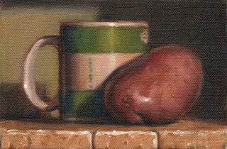 Oil painting of a Désirée potato beside a green and white coffee mug.