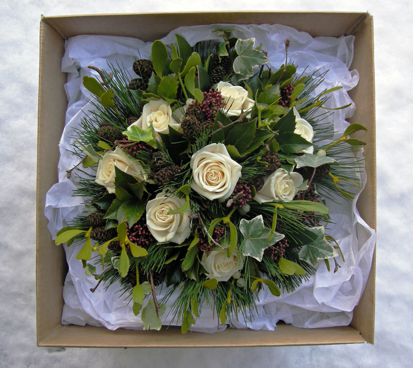 Winter wedding bouquet with a strong Christmas look of roses holly ivy