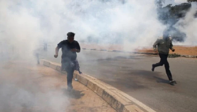 Police in Kakamega run teargas canisters hurled on them during curfew hours.