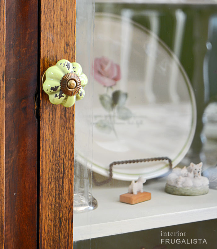 A new green vintage-style ceramic furniture knob on the antique radio cabinet door.