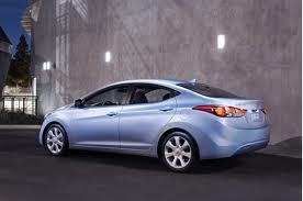 Rear 3/4 view of blue 2011 Hyundai Elantra sedan at night