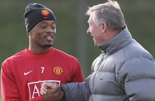 Sir Alex Ferguson chats with Patrice Evra during a training session