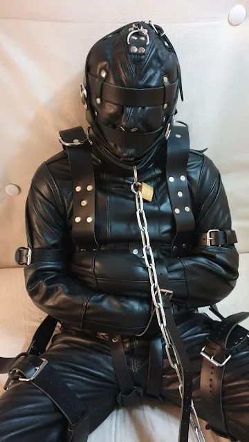 9/12 man bound completely in leather with a hood and straightjacket