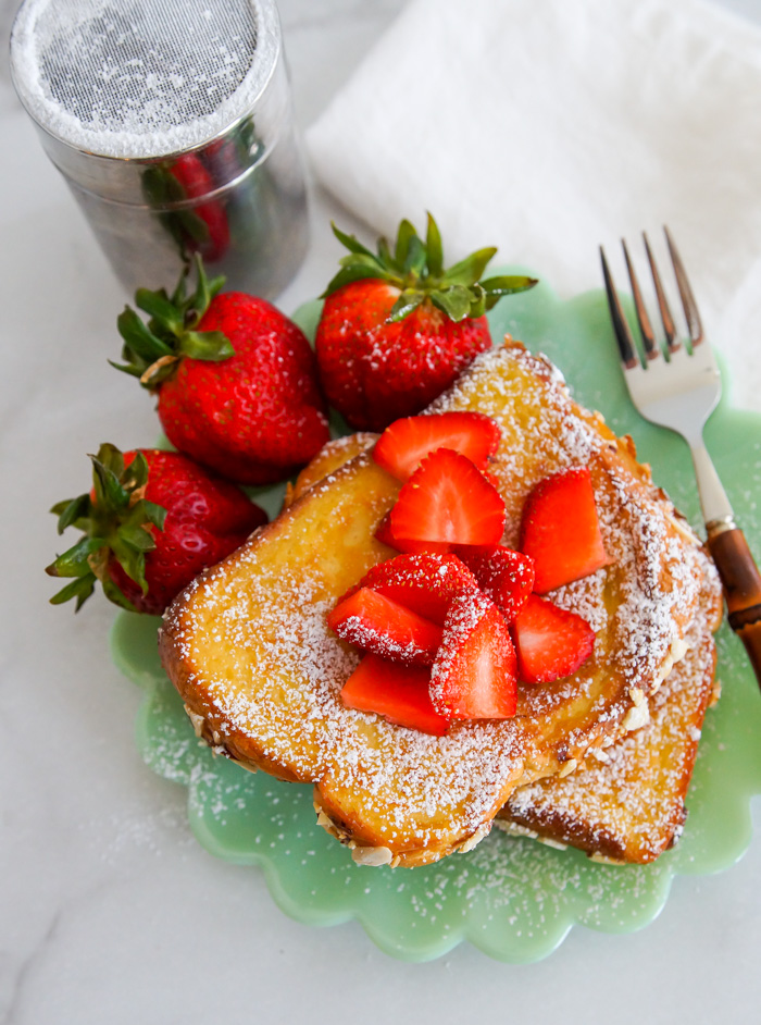 Almond Stuffed French Toast with strawberries on scalloped Pioneer Woman jadeite plate