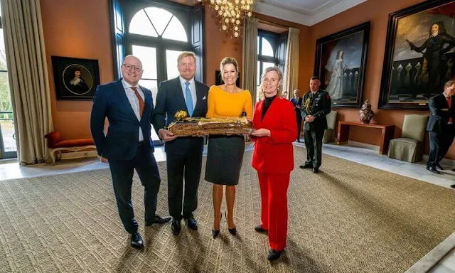 Queen Maxima wore a yellow wool and cahmere sweater by Natan and gray midi skirt by Natan. King Willem-Alexander