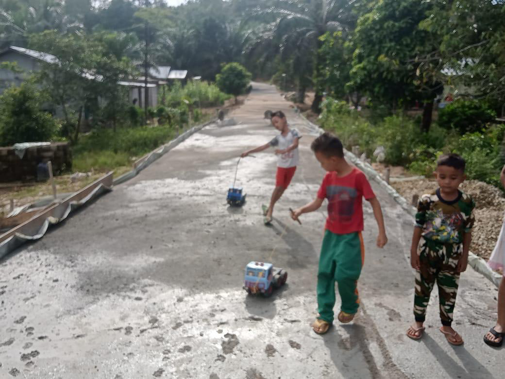 Riang gembira anak-anak bermain di jalan baru yang di kerjakan program TMMD ke 111 kodim 1202/skw