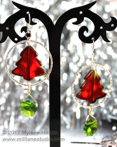 Red Christmas tree suspended inside a silver hoop with a dangling green marguerite bead below it.