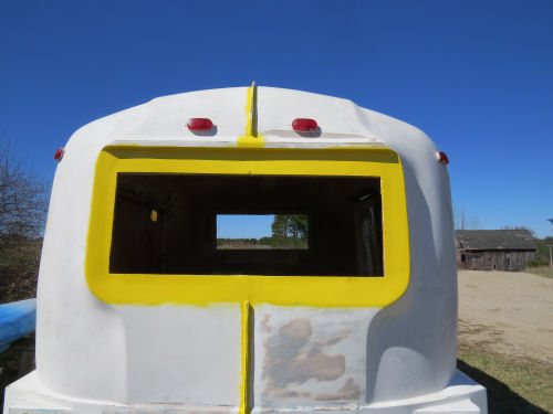 partially painted yellow and white fiberglass trailer