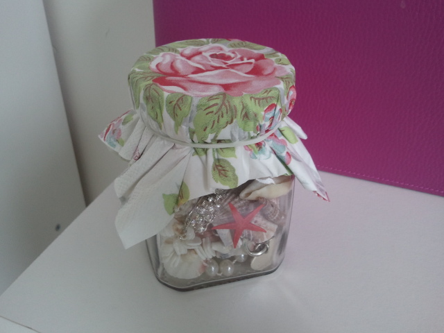 Floral napkin elasticated over old coffee jar