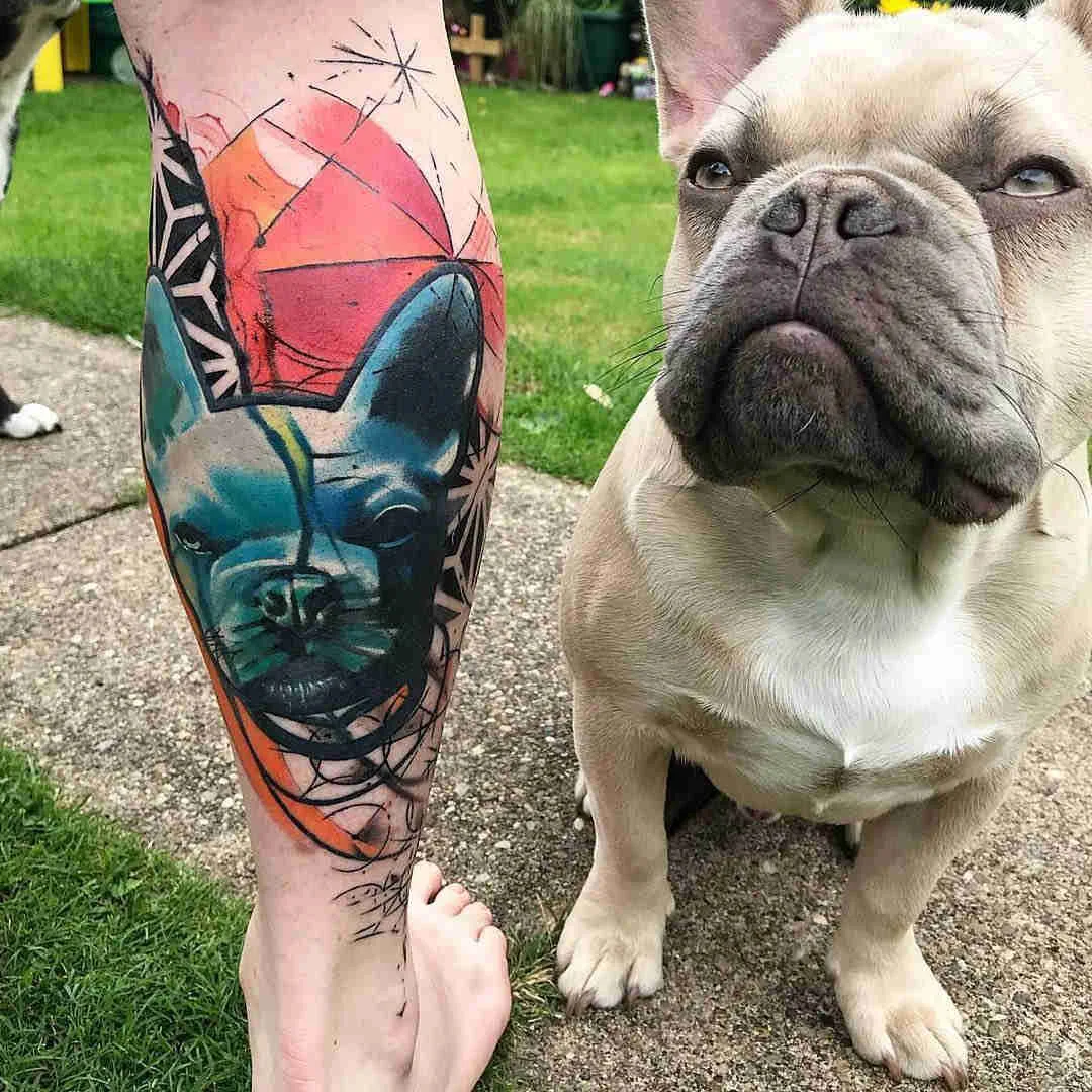 Vemos la imagen de un bulldogo posando junto a  su dueño que luce un tatuaje en homenaje a su perro