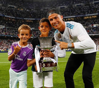 Christiano Ronaldo poses with his son with the trophy after his 5 match ban