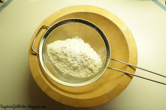 A sieve filled with flour resting in a bowl