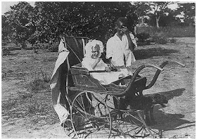 White child in baby carriage attended by black boy. ca. 1924.