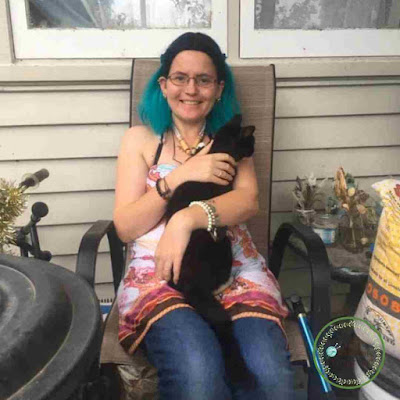 Picture of arjaye sitting outside with her cat