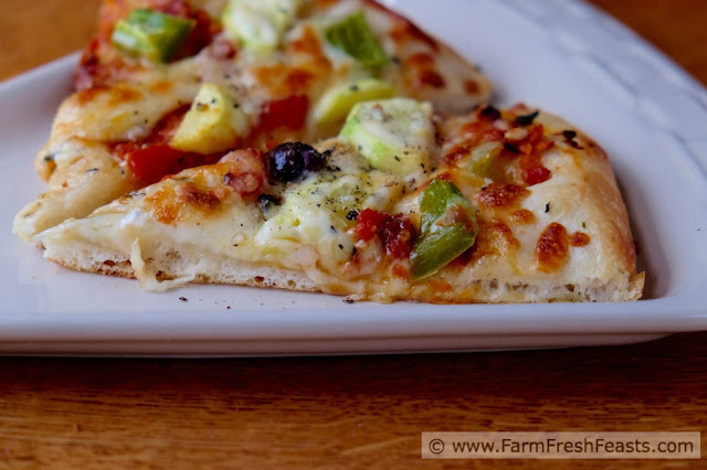 This pizza is a vegetarian's Late Summer Dream. Squash, peppers, olives and slow-roasted tomatoes covered with cheese.