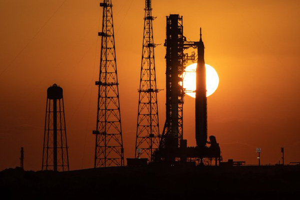 The Sun rises behind NASA's Space Launch System rocket at Kennedy Space Center's Pad 39B in Florida.
