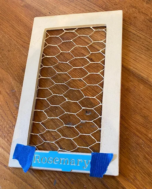 Photo of framed chicken wire with rosemary stencil