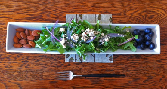 slim salad serving of arugula red onions feta with almonds and blueberries plated