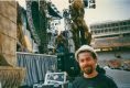 Tom Bowser standing in front of stage scenery and some FOH (Front Of House) speaker cabinets/boxes in front of the stage of The Rolling Stones Voodoo Lounge Tour.