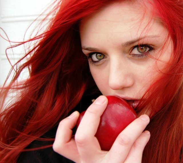 beautiful red headed girl eating apple