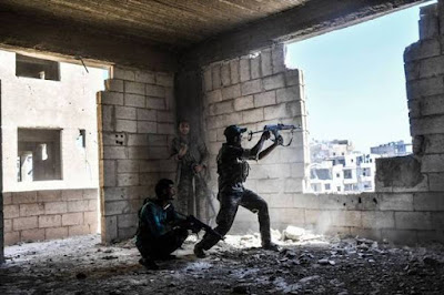 Members of the Syrian Democratic Forces fire their arms during a battle against Islamic State (IS) group jihadis.