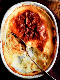 Classic baked rice pudding with a nice dark skin served with a spoon