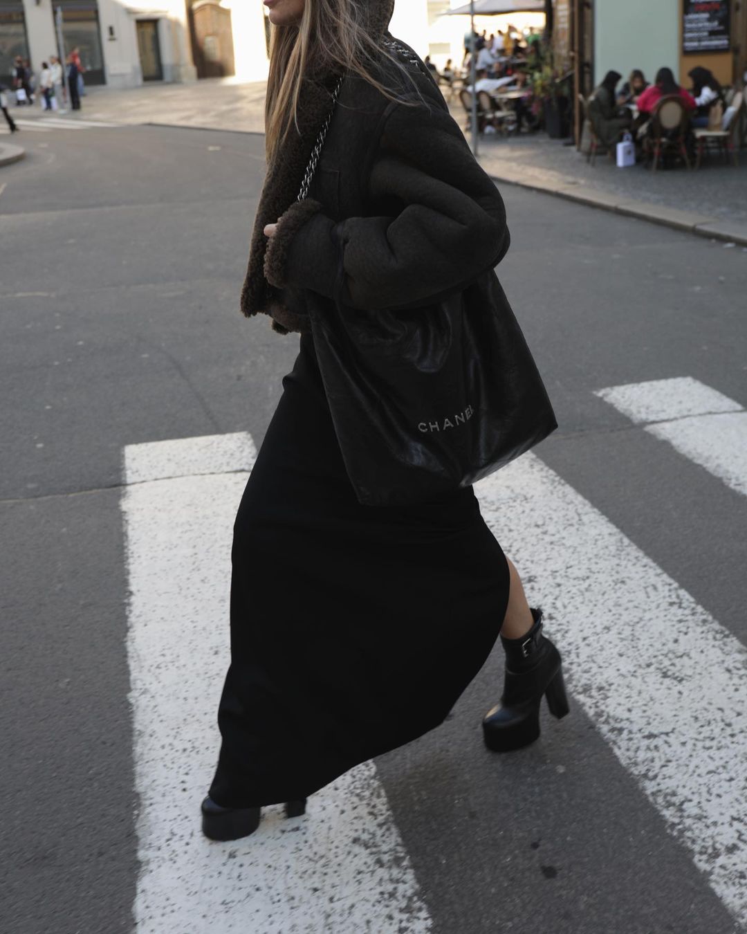 Bohemian outfit idea with a Chanel 22 bag, a black maxi skirt, and a black leather shearling bomber