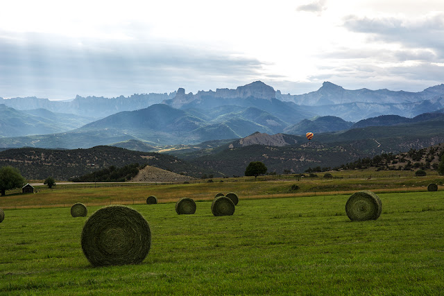 Parting shot of the Cimmarrons with hot air balloon and sunbeams in a farm field of hay.