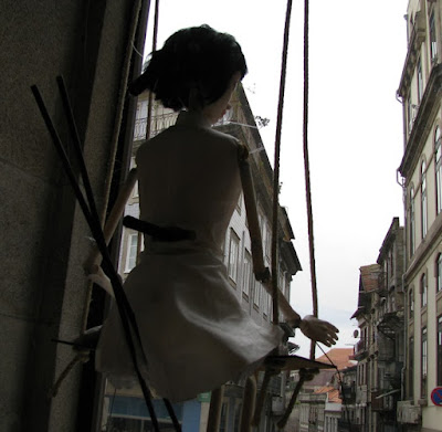 Marioneta numa vitrine em frente a alguns prédios