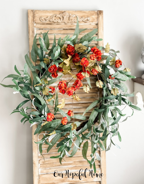 fall wreath displayed on vintage shutter