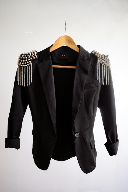 Epaulettes cloutées et veste noir de type blazer