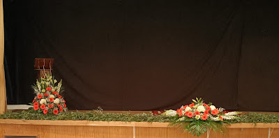 Escenario con centros florales y verdes para la presentación de la falla