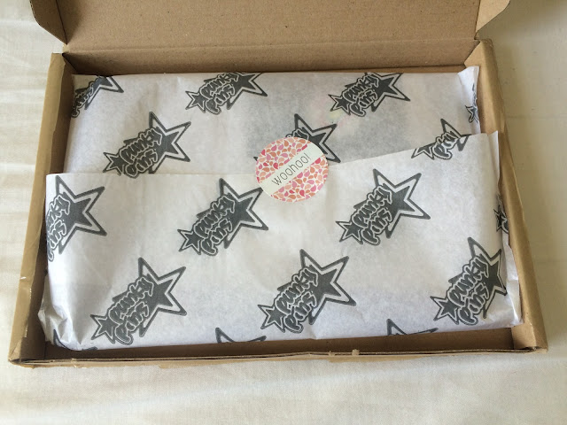 Open brown parcel with punky pins logo tissue paper and pink sticker reading Woohoo