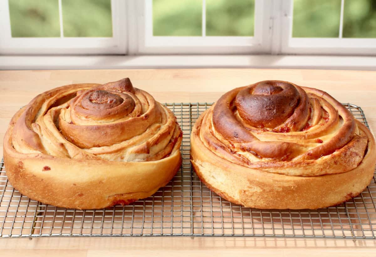 Fresh Strawberry Cinnamon Roll Cake (with Lemony Glaze) on a cooling rack.