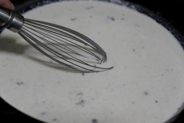 Milk being whisked into the flour, in the skillet.