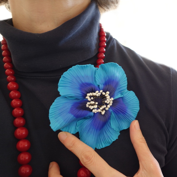 broche fleur bleue La Fille du Consul sur collier rouge