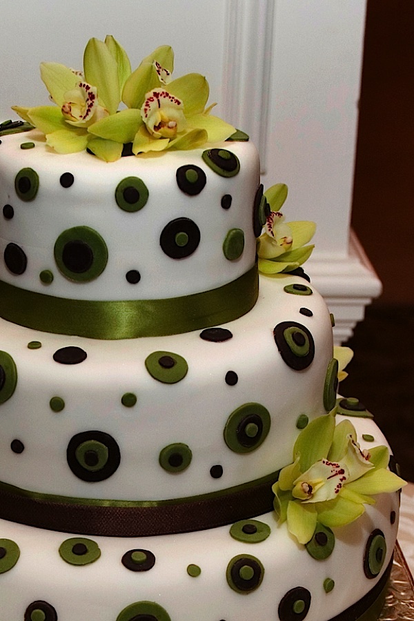 Modern three tier wedding cake with green and black circles green ribbon