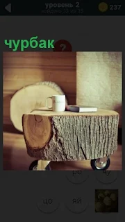 В комнате стоит стол на колесах, который сделан из чурбака