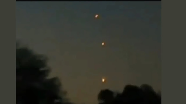 3 UFOs flying in a vertical line and one of them supposedly lands according to the woman that yells out.