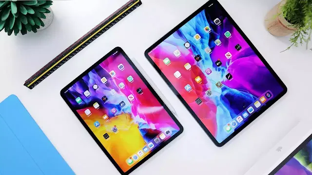 Two 2024 iPad Pros displayed on a white table, showcasing their vibrant Ultra Retina XDR screens with dynamic wallpapers.