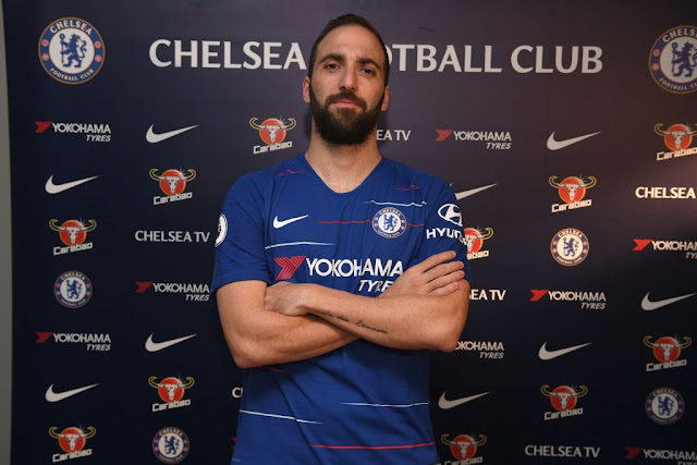 Higuain pose for a picture in a chelsea jersey after completing his move to stamford bridge on loan.