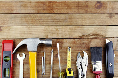 a variety of tools are laid out on a wooden work bench