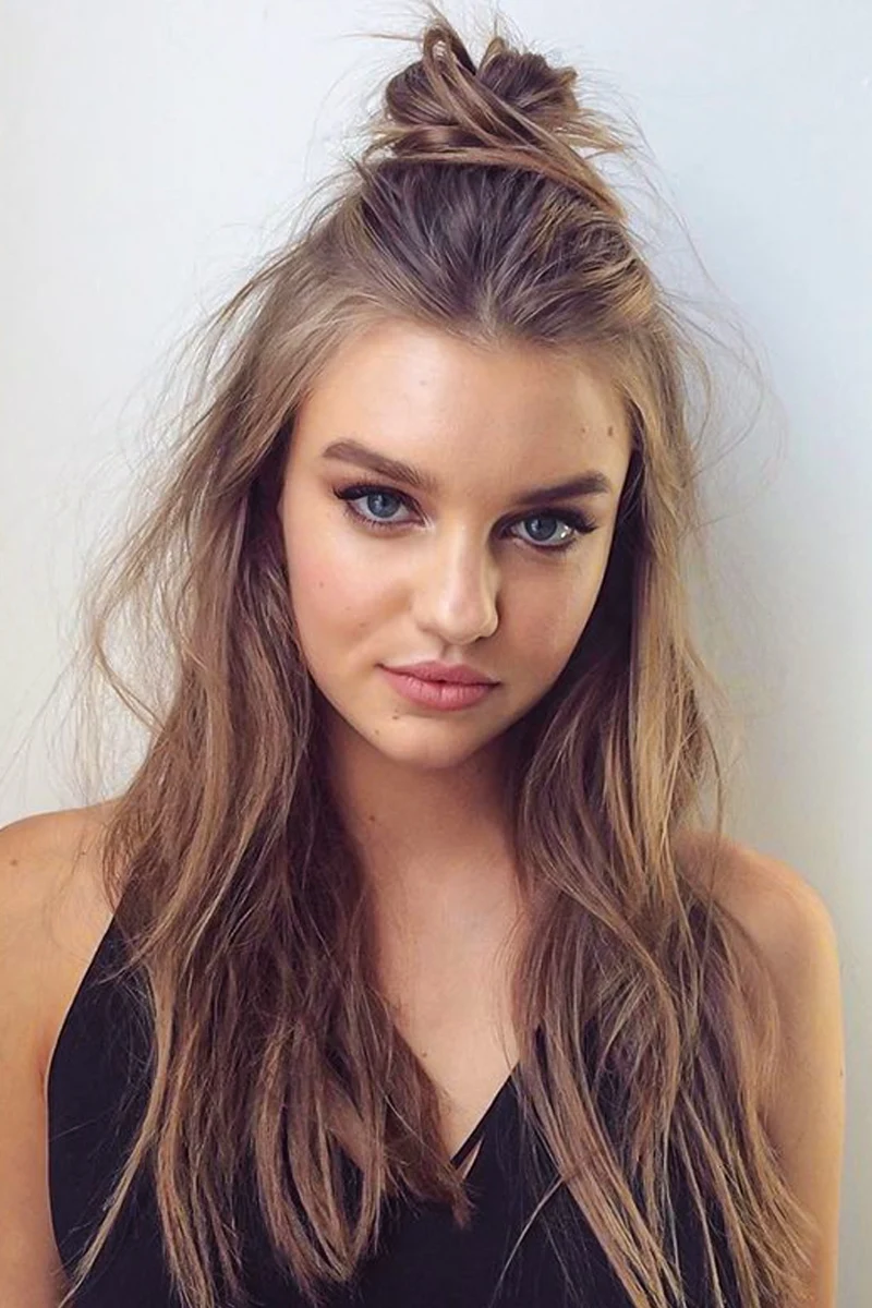 portrait of a young woman with long hair styled in a top knot hairstyle