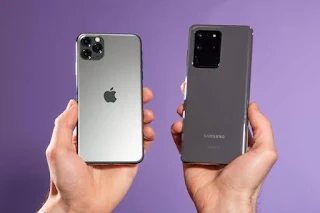 Hands holding two rival phone brands Apple And Samsung