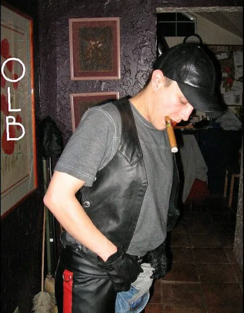 Oregonleatherboy wearing black leather vest and playing with crotch with cigar and mouth