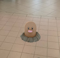 Screenshot of Pokemon Go showing a Diglett emerging from the ground