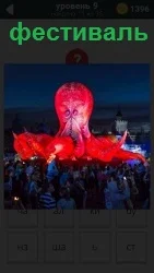 На фотографии демонстрация фестиваля с поднятием красного шара и большого количества людей